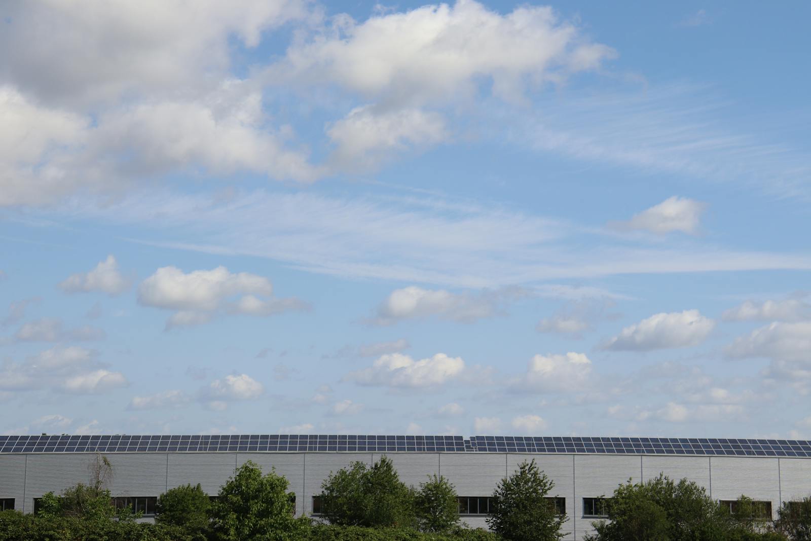 PV-Module auf Industriedach unter blauem Himmel, Symbolbild hagelresistente PV-Module Gewerbe