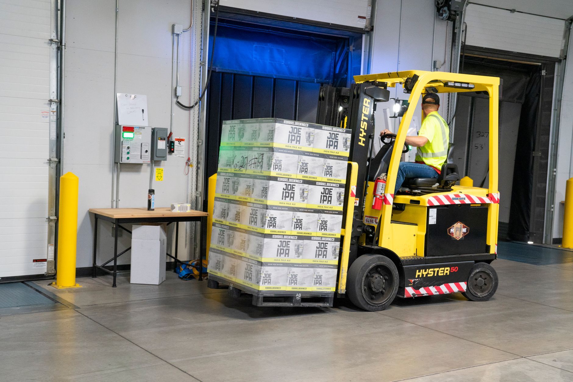Warehouse worker moving goods with a forklift