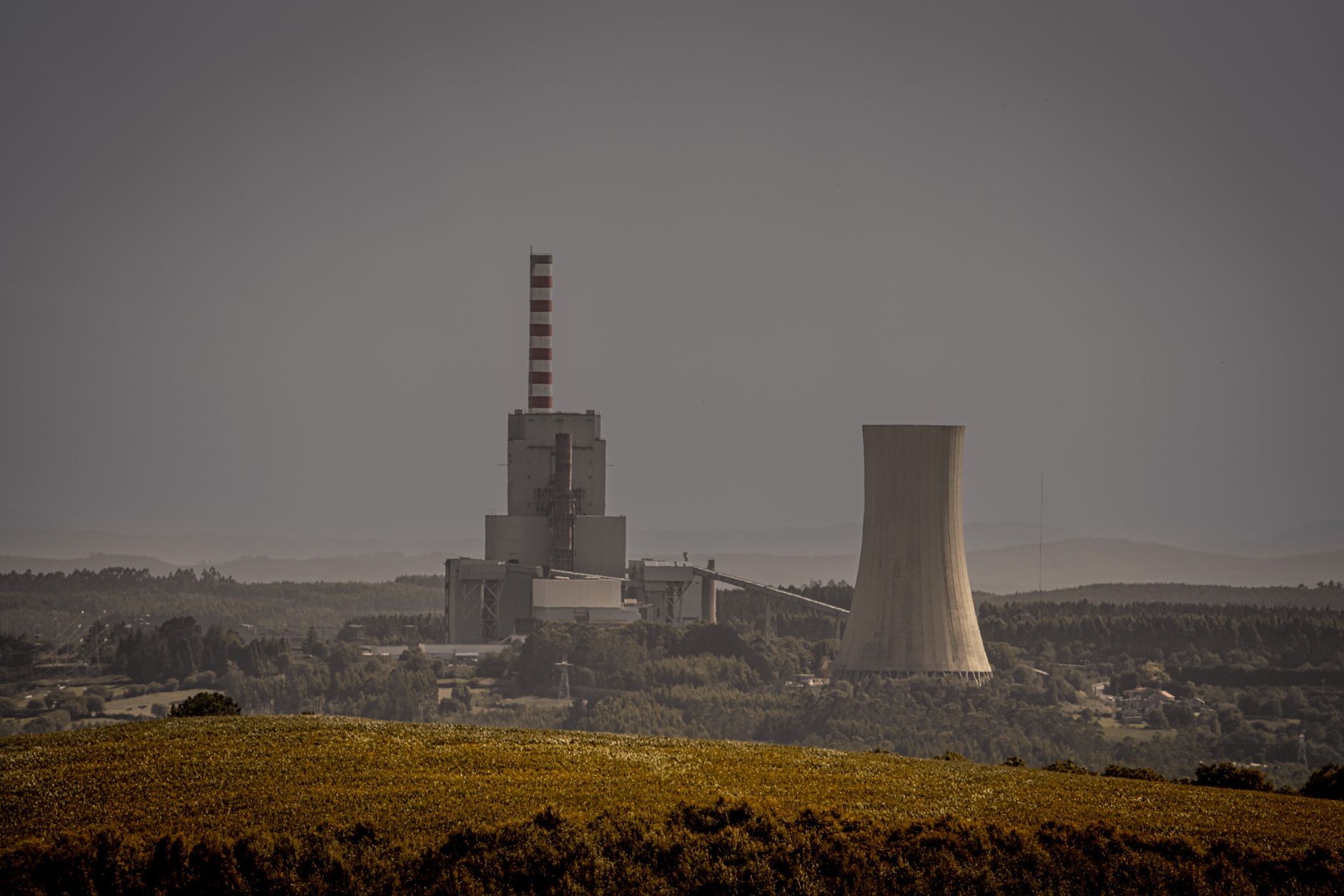 Power plant with a cooling tower and chimney in a wide landscape