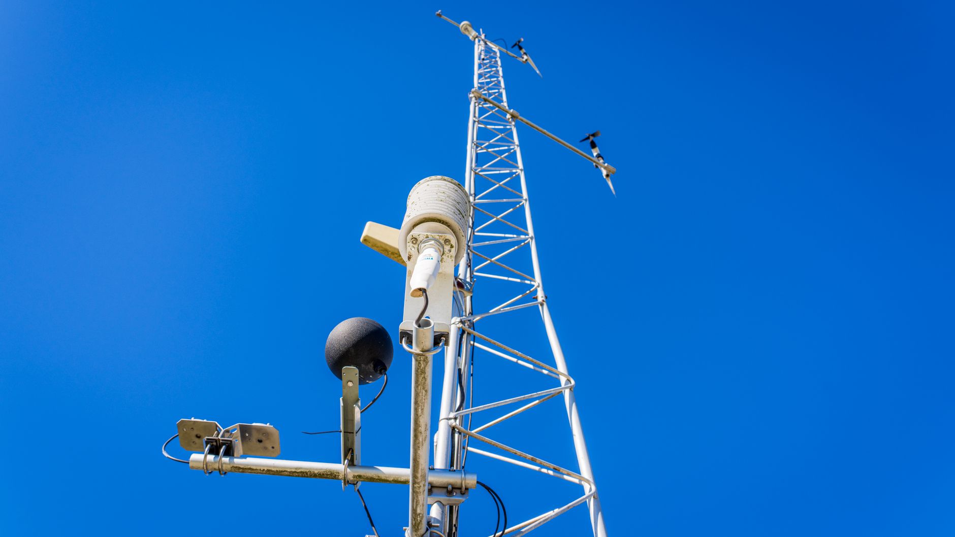 Messmast mit Wettersensoren vor blauem Himmel