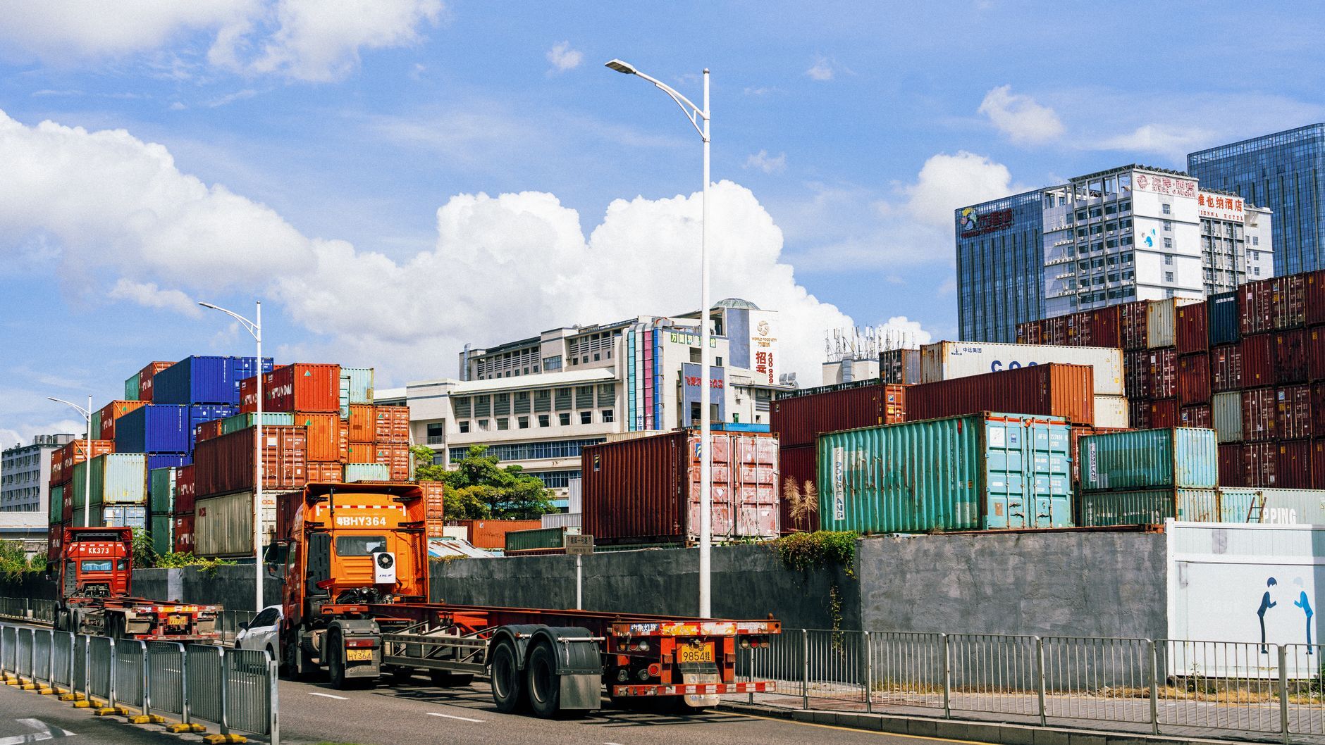 Truck in front of stacked shipping containers at a port