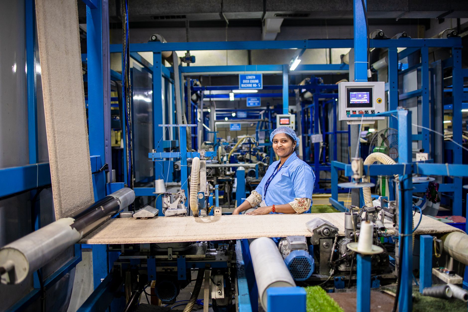 Arbeiterin an einer Maschine in einer Textilfabrik