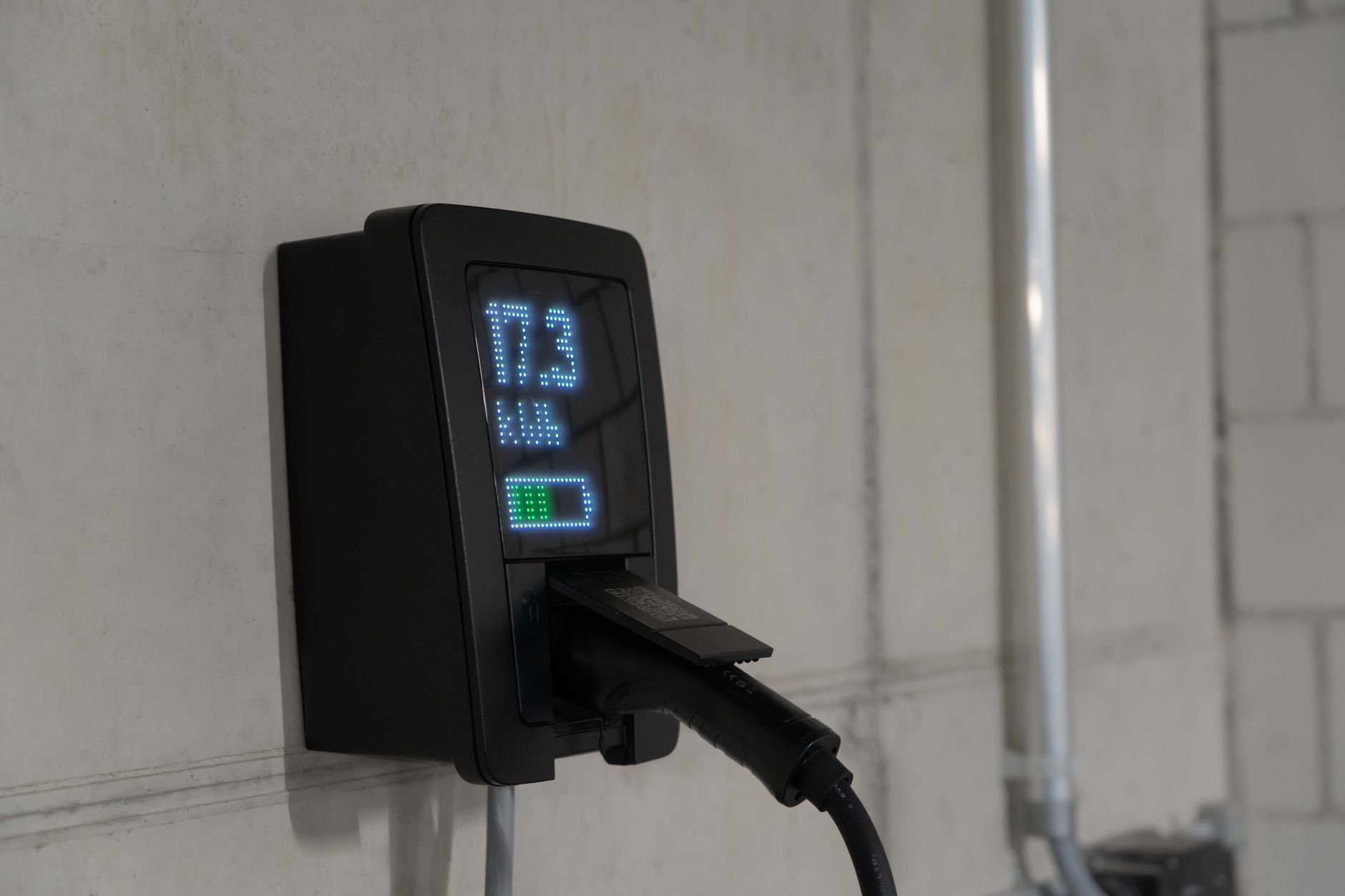 Wallbox mit Ladeanzeige an einer Betonwand