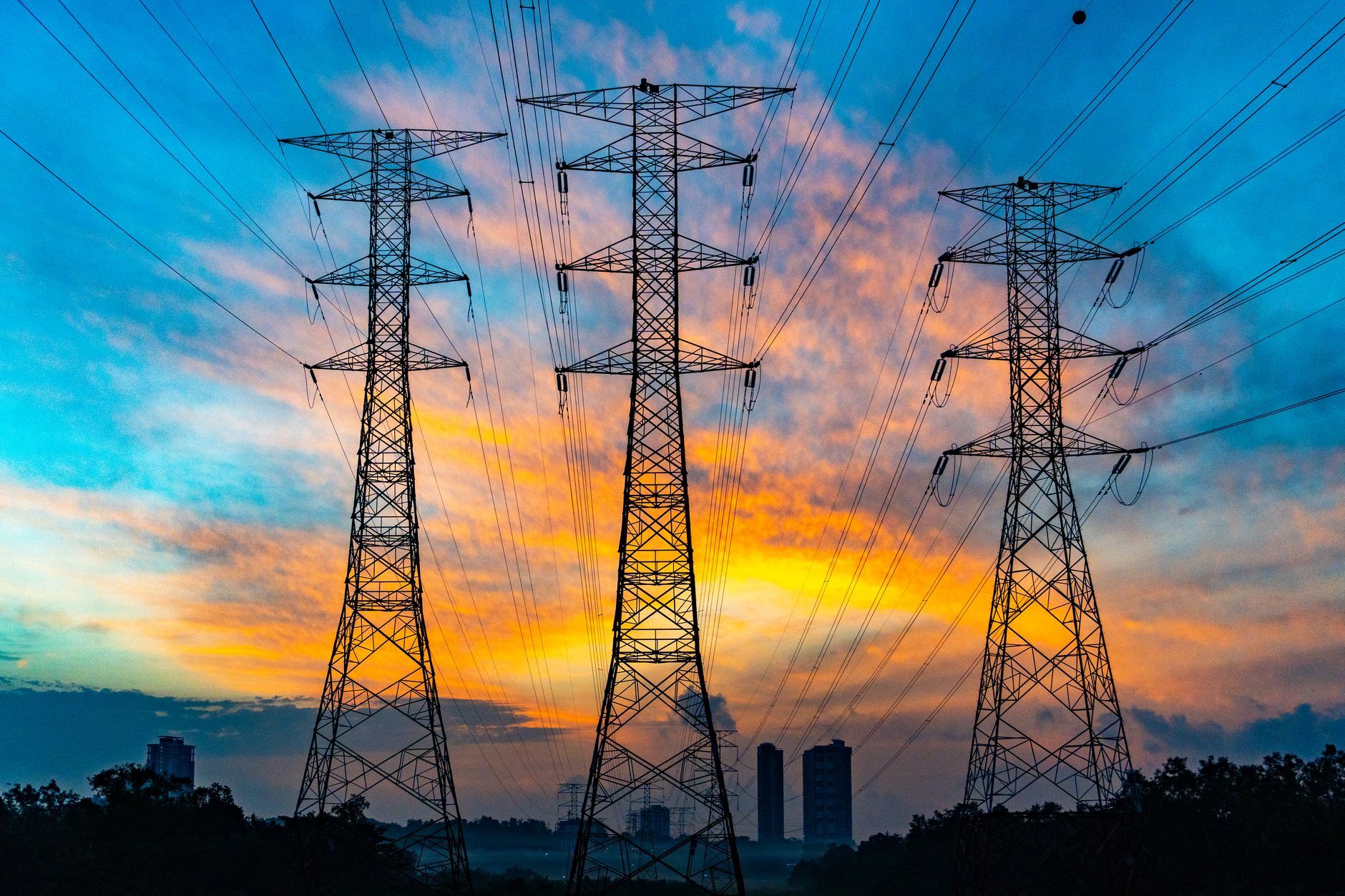 High-voltage pylons against a sunset sky