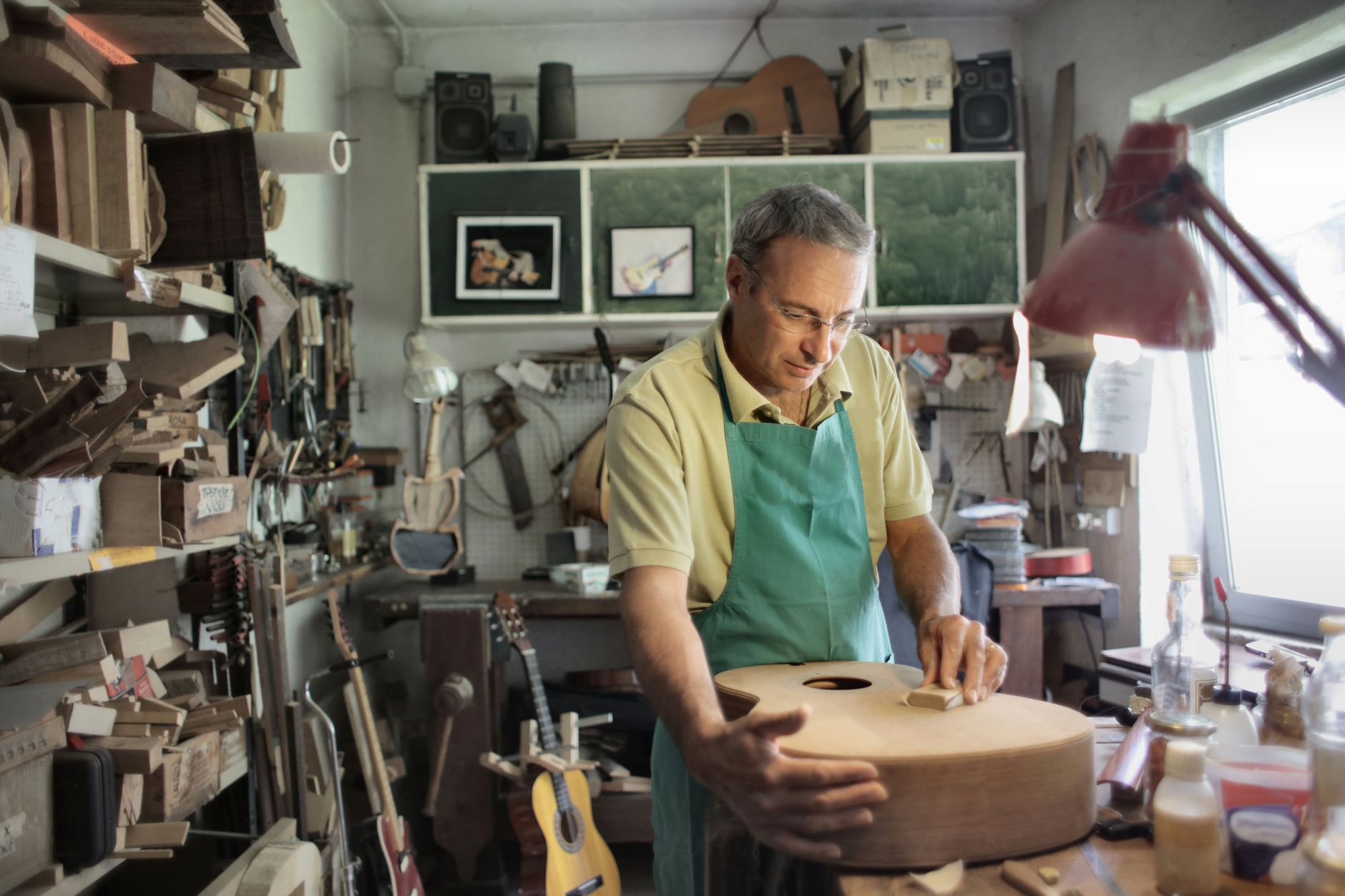 Handwerker schleift in seiner Werkstatt den Korpus einer Gitarre