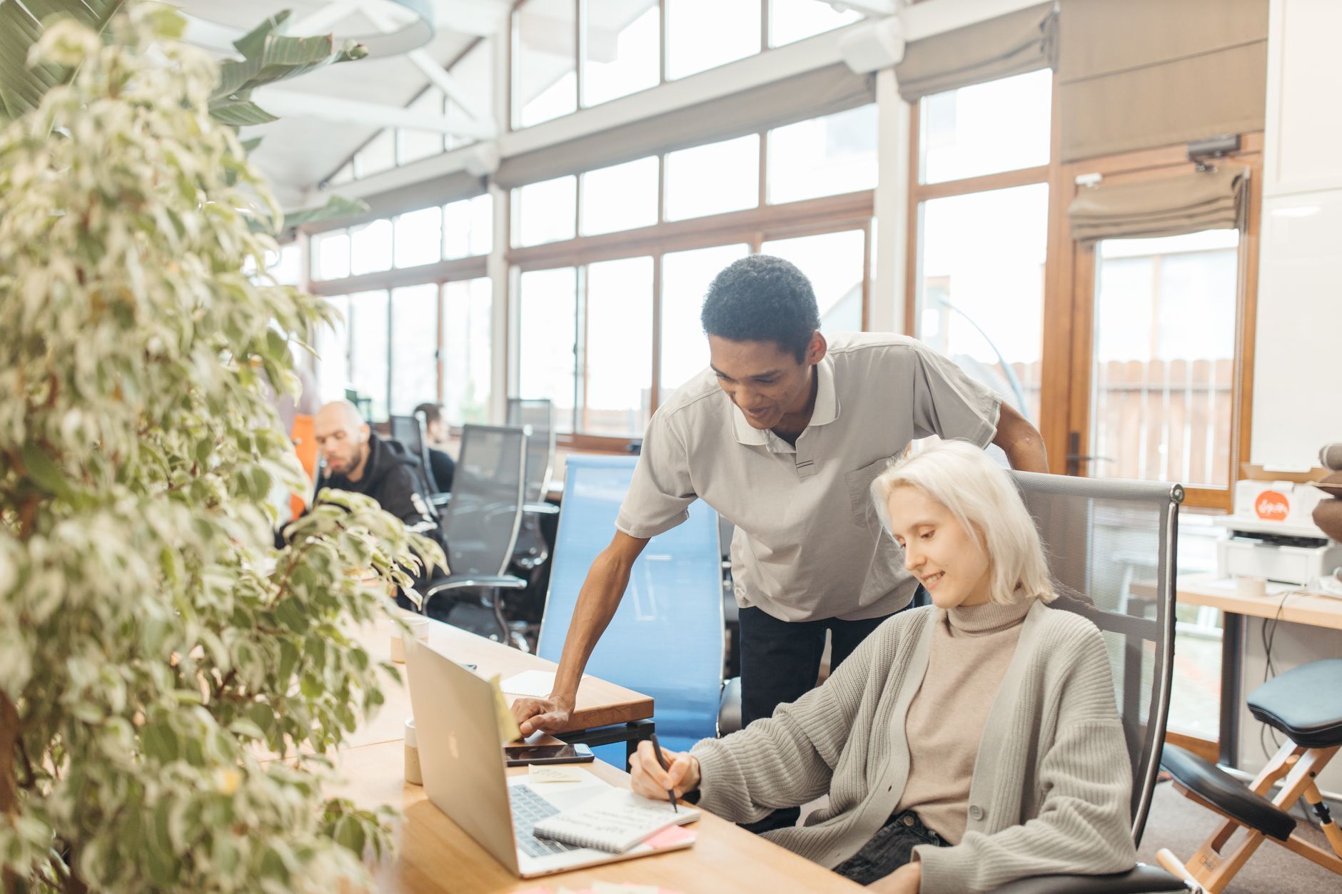 Two colleagues working together at a desk in a bright office