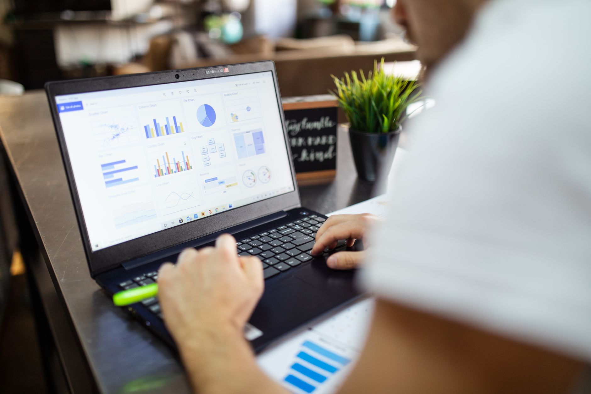 Person arbeitet an einem Laptop mit Diagrammen auf dem Bildschirm